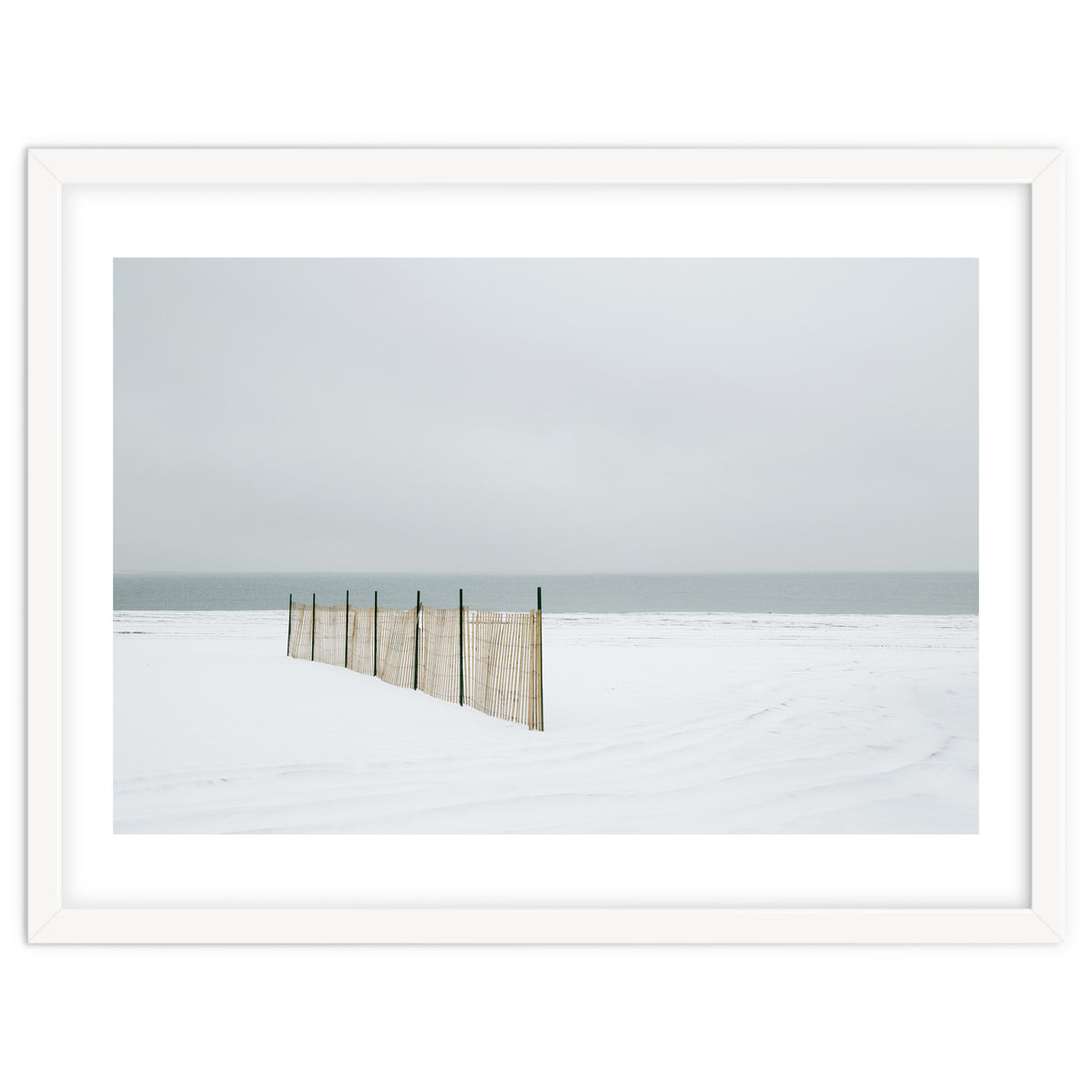 Wood fence in the winter snow beach
