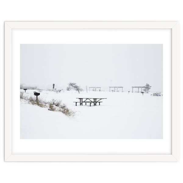 Tables and benches in a snow-covered park