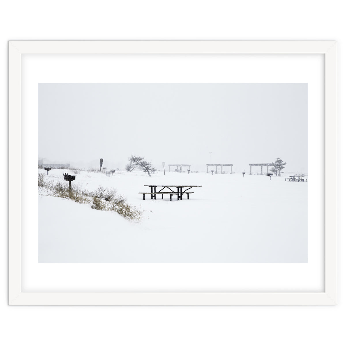 Tables and benches in a snow-covered park