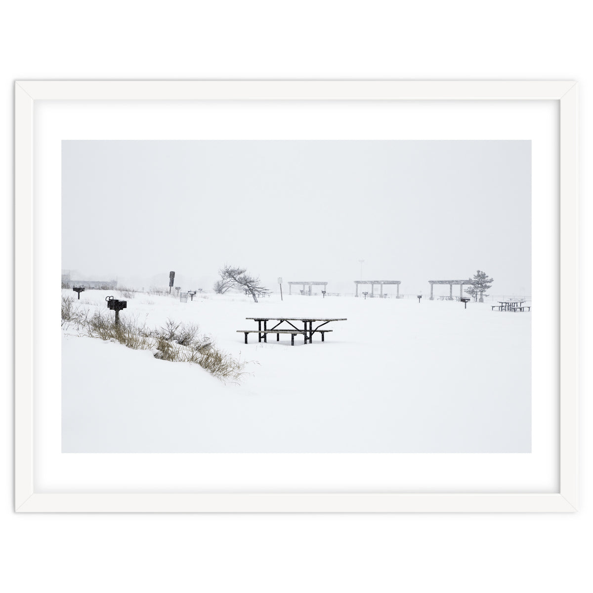 Tables and benches in a snow-covered park