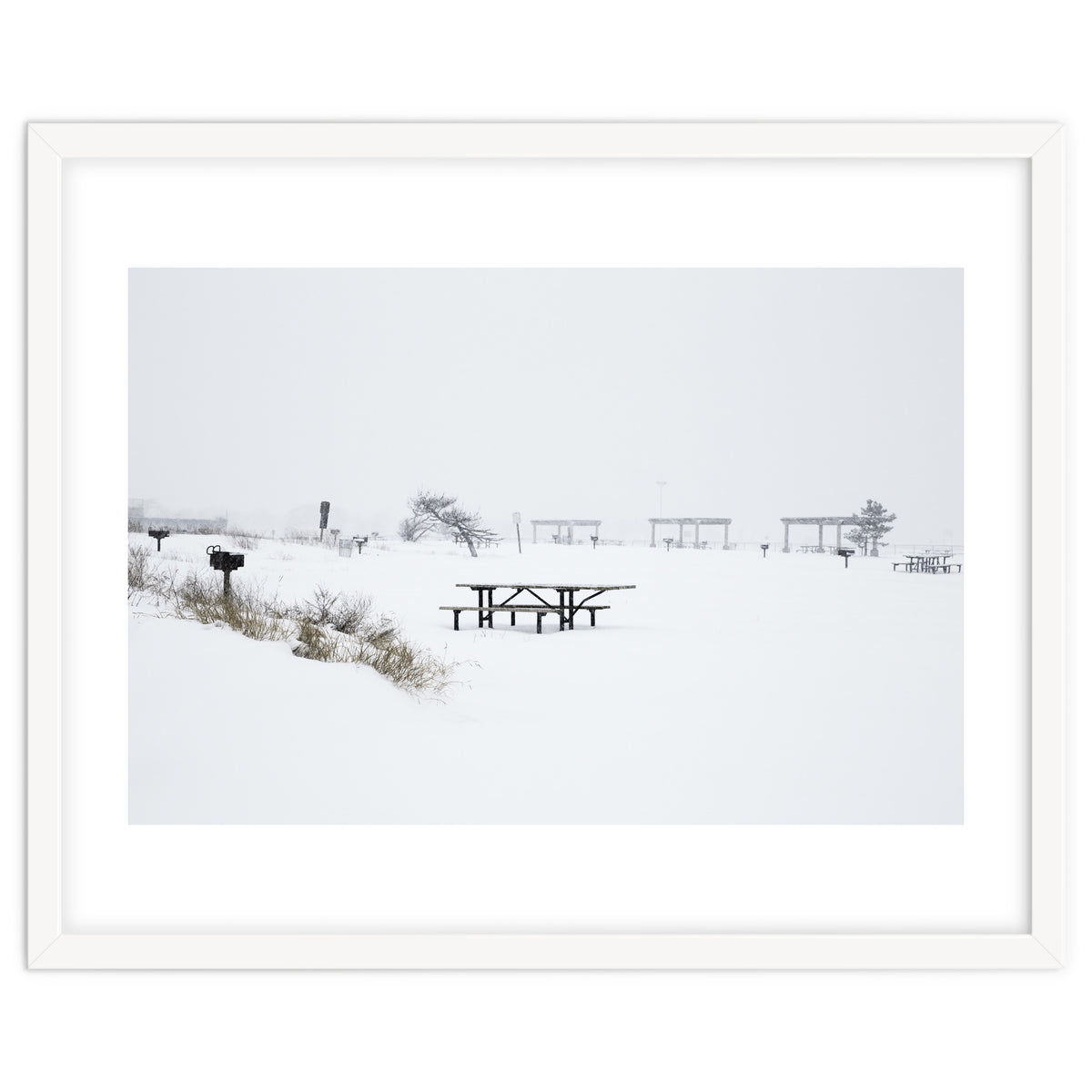 Tables and benches in a snow-covered park